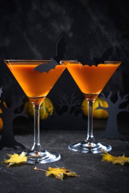 Yarasalar ve Cadılar Bayramı için dekor turuncu martini kokteyl parti, koyu arka plan üzerinde