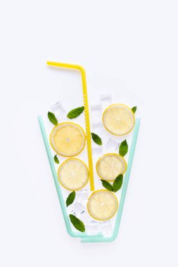 Yaratıcı yaz içeceği kompozisyonu. Limon dilimleri, nane yaprakları ve buz küpleriyle. Minimal yassı limonata içeceği konsepti. Beyaz arkaplanda