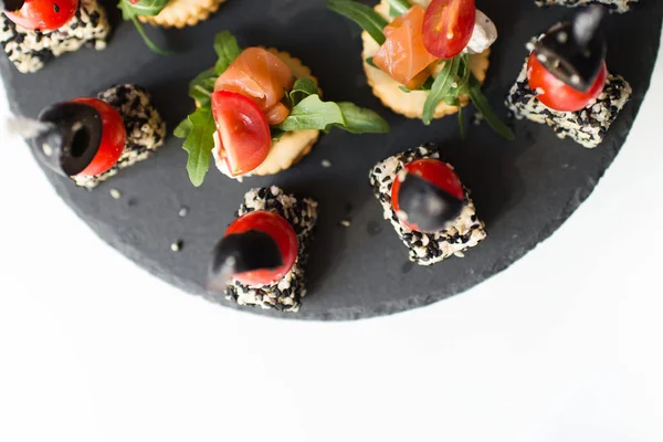 Saborosos e deliciosos stands de catering em bandejas de pedra e em branco — Fotografia de Stock