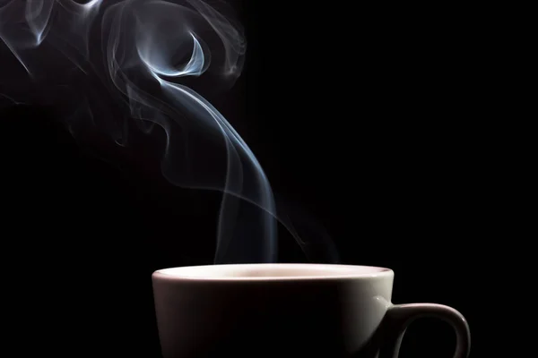 white cup with smoke from hot coffee on black background