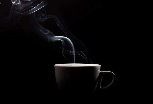 Fragrant coffee on black background. Smoke from hot coffee.