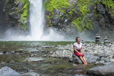 Batad, Filipinler - Mayıs 02: Batad üzerinde 02 Mayıs 2018 Türkiye bir şelale yakınındaki Ifugao azınlık kızdan. Kuzey Filipinler dağların çoğunlukla canlı Ifugao azınlık