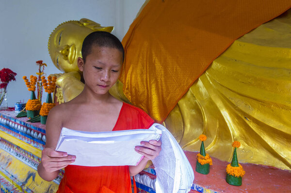 LUANG PRABANG , LAOS - AUG 12 2018 : Novice monk in Luang Prabang Laos on August 12 2018. It is estimated that about 1 in 3 male Laotians join a monastery at least for a while