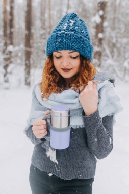 Kız şapka ve kar ile ormandaki bir kazak