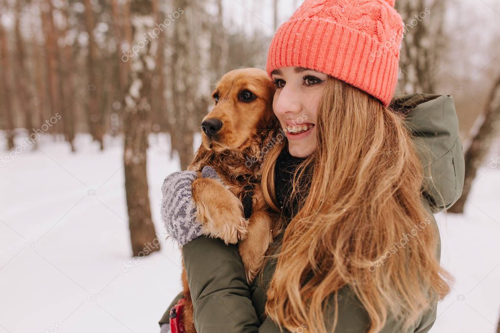 A girl with braces with a dog walk in the winter forest