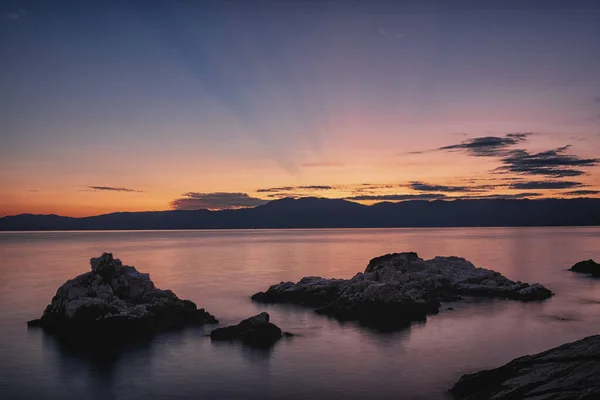 Calm sea with rocks at sunset with red sky, Rijeka, Croatia — Stock Photo, Image