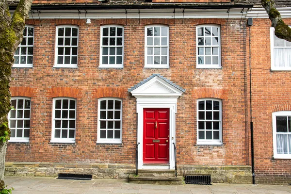 Casa inglesa con ladrillos rojos, ventanas blancas y puerta roja, Inglaterra — Foto de Stock