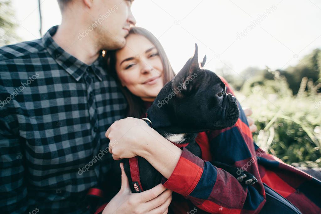 happy hipster couple with bulldog , summer vacation. stylish family with funny dog resting, cute moments
