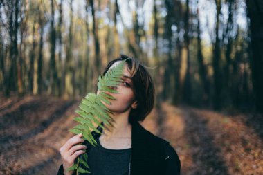 fern arasında fern çalılar ile şık hippi kız kadın gezgin atmosferik an orman yaratıcı portresi bırakır