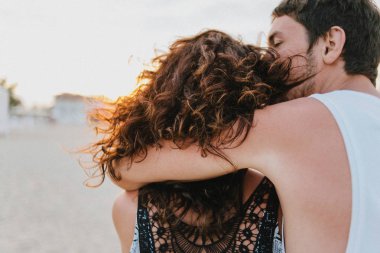 Güzel kız ve adam kumlu bech üzerinde gün batımında