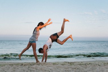 Güzel kız ve adam kumlu bech üzerinde gün batımında