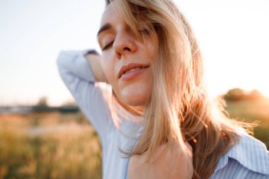 Yaz aylarında gün batımında kulaklı bir alanda güzel bir kızın portresi