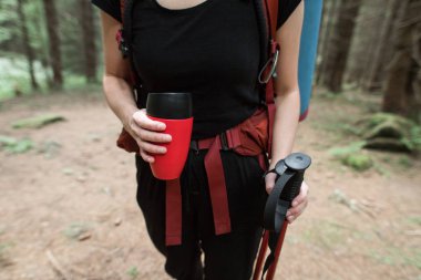 Çay vakum balonun üzerinden metal bardağa dökmek olmak. Seyahat, backpacking, hiking, açık rekreasyon, başarı, ilham kavramı,