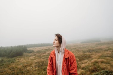 Yan görünüm portre yakışıklı erkek onun kulaklık dışında müzik dinlemek puslu doğada yürüyüş. İnsanlar, duygu ve seyahat kavramı.