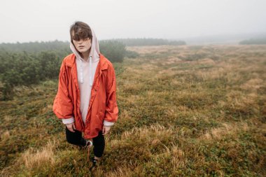 Yan görünüm portre yakışıklı erkek onun kulaklık dışında müzik dinlemek puslu doğada yürüyüş. İnsanlar, duygu ve seyahat kavramı.