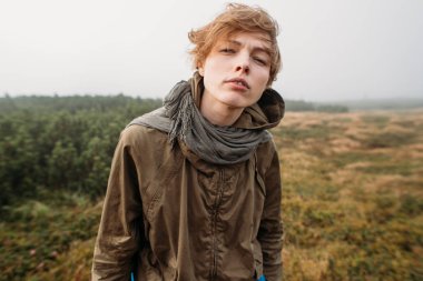 Yan görünüm portre yakışıklı erkek onun kulaklık dışında müzik dinlemek puslu doğada yürüyüş. İnsanlar, duygu ve seyahat kavramı.