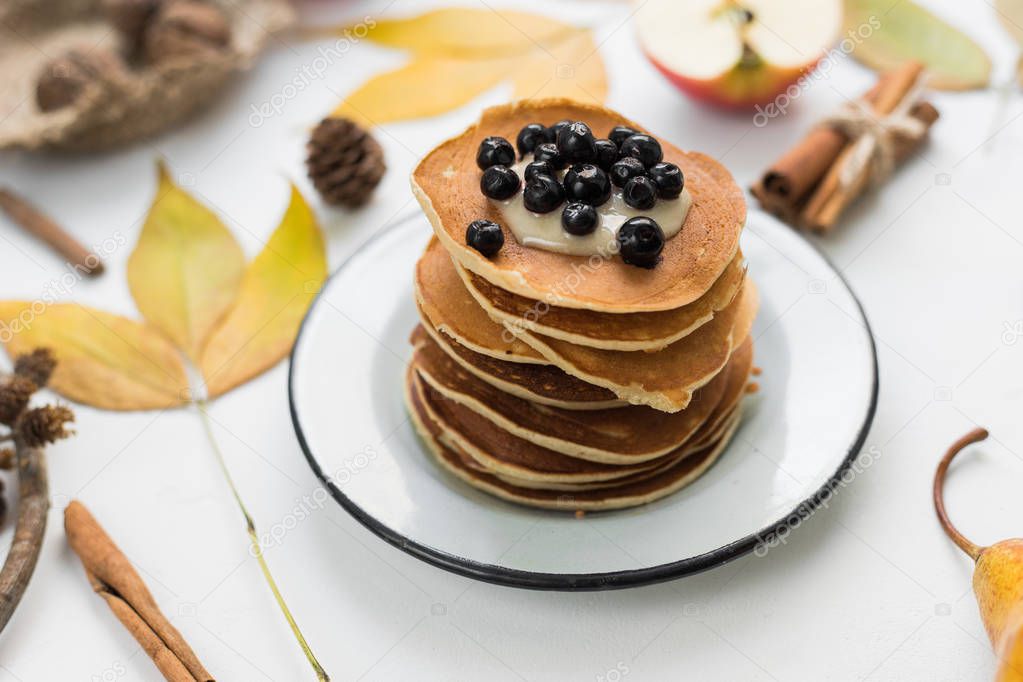 A composition of nuts, pancakes, bananas and apple on a nice autumn themed background