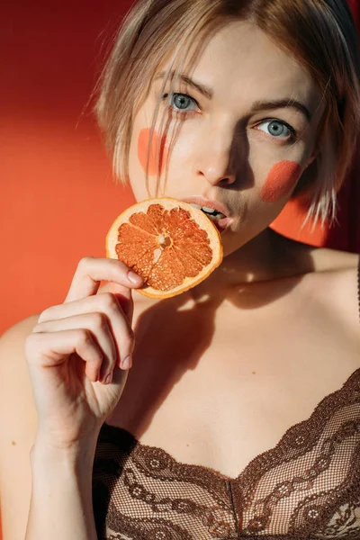 Modelo bonito em roupa interior com laranja — Fotografia de Stock