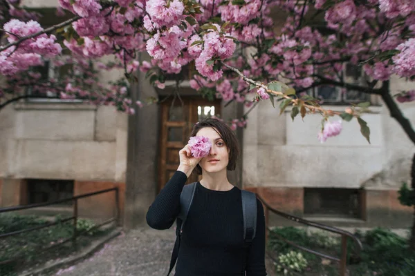 Belle fille souriante près d'un arbre sakura en fleurs — Photo