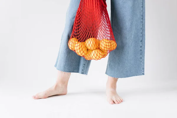 holding string bag with lemons zero waste