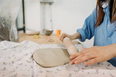 Genç bir kadın, çömlekçi, kendi elleriyle kendi atölyesinde çatal bıçak yapıyor.