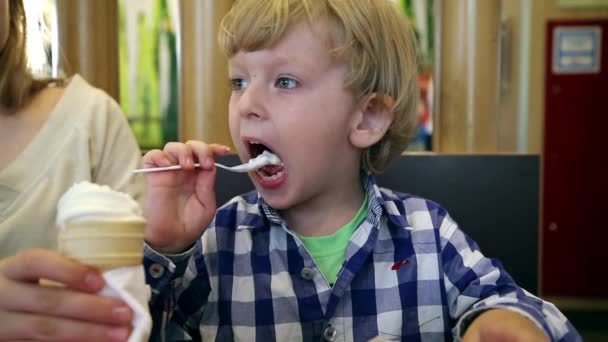 Хлопчик їсть морозиво в кафе — стокове відео