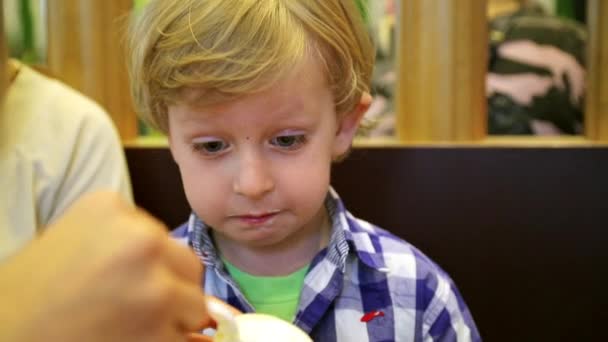 Fiú eszik fagylaltot egy kávézóban — Stock videók