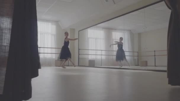 Балерина танцует в студии перед зеркалом — стоковое видео
