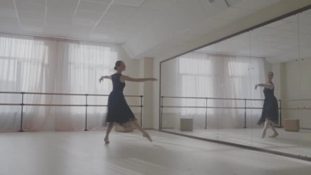 Балерина танцует в студии перед зеркалом — стоковое видео