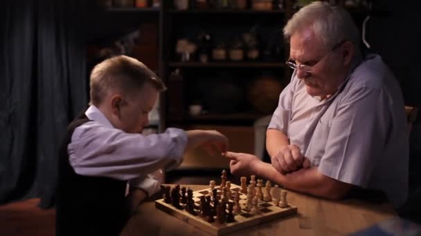 Feliz abuelo juega al ajedrez con su nieto pequeño . — Vídeos de Stock