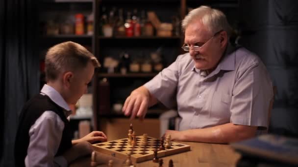 Feliz abuelo juega al ajedrez con su nieto pequeño . — Vídeos de Stock