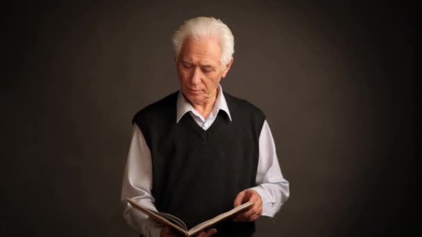 Homme âgé pose avec un livre — Video