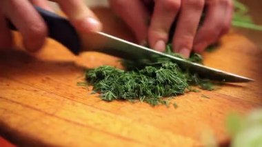 Cook dereotu ahşap masanın üstüne kesmek.