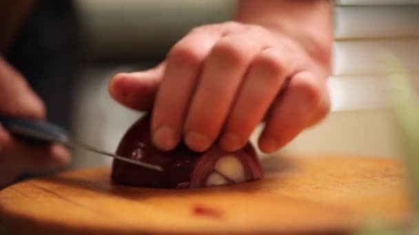 Кука цибулю ріже на столі — стокове відео
