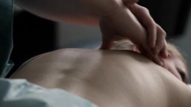 Spa Masaj terapist yordamı kadına spinal masaj yapar..