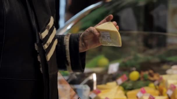 Una mujer en un supermercado comprando un queso — Vídeo de stock