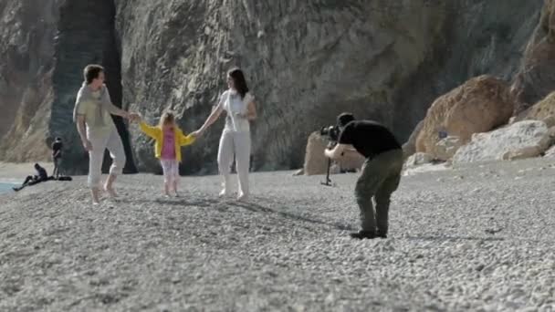 Cameraman tire sur un couple marié avec un enfant sur la plage — Video