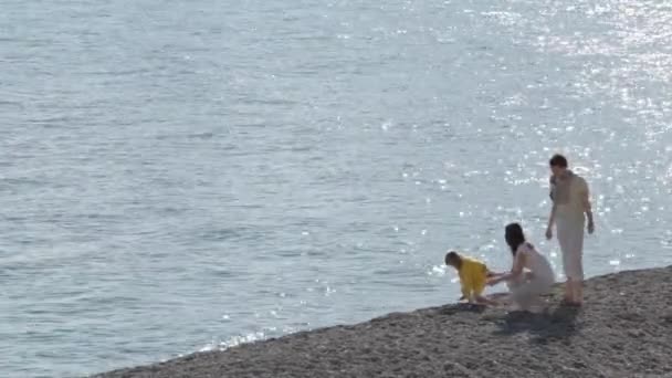 I genitori felici e la figlia camminano sulla costa nella giornata di sole — Video Stock