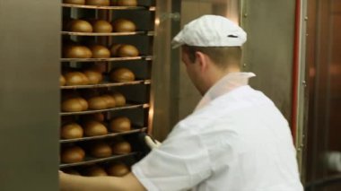 Baker bir fırından ekmek bir rafa kaldırır