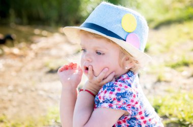 Doğanın bulanık bir arka plan üzerinde mesafe içine bakarak bir headdress mavi gözlü düşünceli bir kız portresi