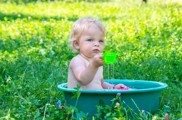 暑い夏の日に通りに水を楽しんで青い目を持つ幼児の赤ちゃん女の子 — ストック写真