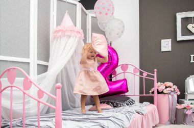 iki yıl, eğleniyor, yatağın üzerine çömelerek dekore edilmiş bir odada oynayan, mutlu sarışın