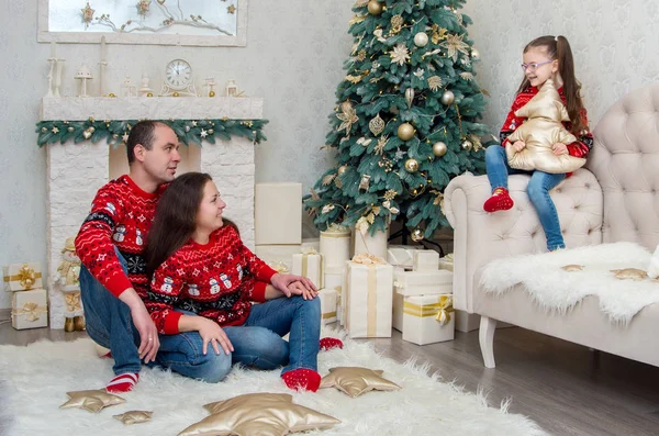 mutlu aile içinde bir odada kırmızı kazak Noel arifesi için dekore edilmiştir.