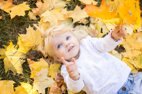 Niña Con Ojos Azules Está Acostada Sobre Las Hojas Caídas —  Fotos de Stock