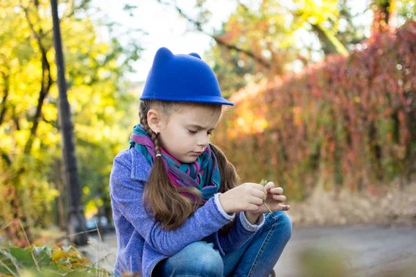 Kleines Mädchen Mit Blauem Hut Sitzt Und Blickt Traurig Nach — Stockfoto
