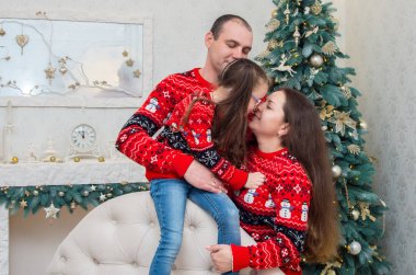 mutlu aile içinde birbirleriyle sarılma kırmızı kazak Noel arifesi için dekore edilmiştir.