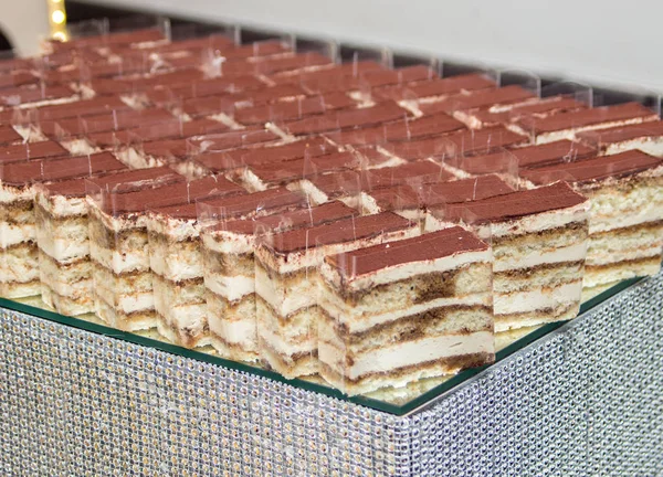 cake with cream filling stand in a row on the table for a banquet