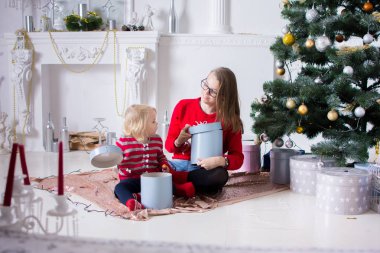 kırmızı kazak iki kız kız hediyeler Noel ağacı yakınındaki Noel arifesinde açın.