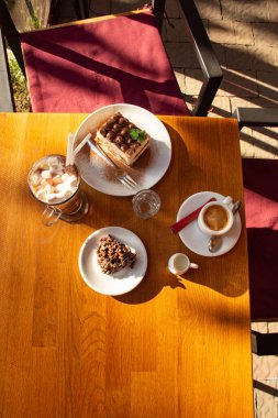 Kremalı bir fincan mis kokulu kahve, bir tiramisu keki ve masanın üzerindeki kafede bir parça yulaflı kurabiye. Kafe kavramı..