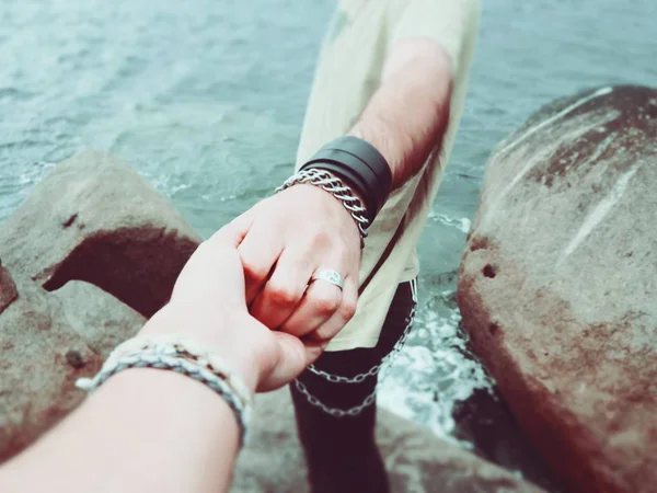 couple holding hands on the lake